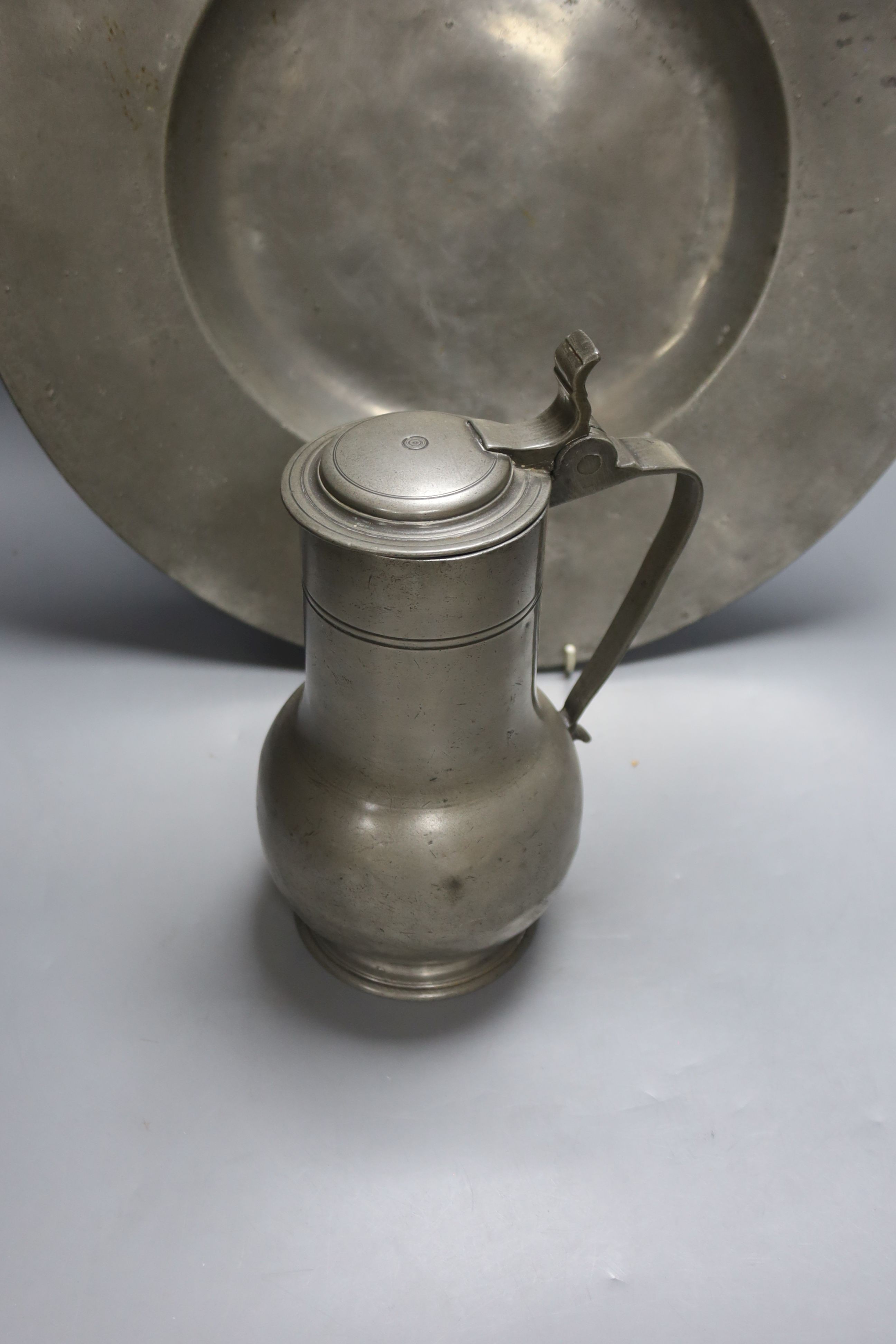 A 17th century pewter charger (possibly Nicholas Kelk) 47cm and a late 17th century pewter flagon, 25.5cm